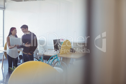 Happy business colleagues using laptop at office