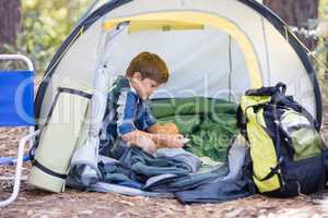 Little boy sitting in tent while hiking