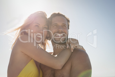 Low angle view of happy couple embracing at beach
