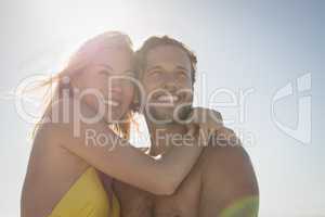 Low angle view of happy couple embracing at beach