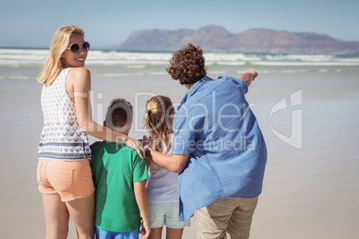 Smiling woman standing with her family at beach