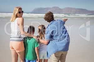 Smiling woman standing with her family at beach