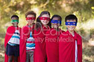 Friends in red superhero costumes standing at campsite