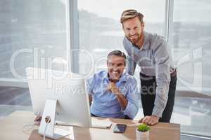 Portrait of smiling executives at desk