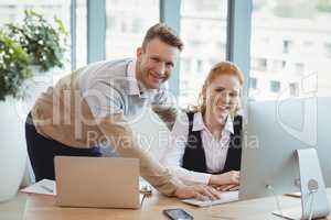 Portrait of smiling executives working at desk