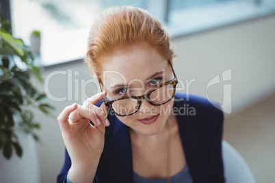 Portrait of executive holding spectacles