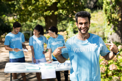 Smiling volunteer pointing at his t-shirt