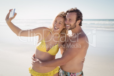 Happy young couple taking selfie at beach