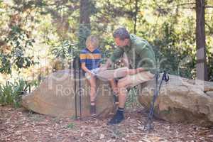 Father and son reading man in forest