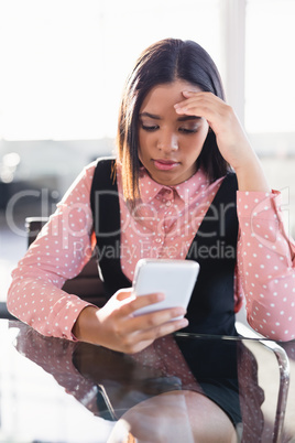 Worried businesswoman using mobile phone