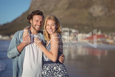 Portrait of happy young couple embracing at beach