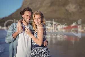 Portrait of happy young couple embracing at beach