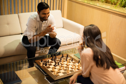 High angle view of smiling business colleagues playing chess