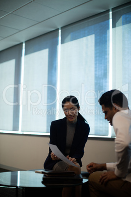Business people discussing over document at office