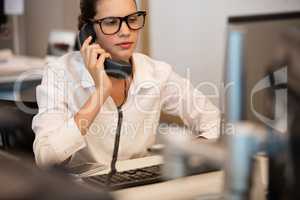 Businesswoman using telephone while sitting at office