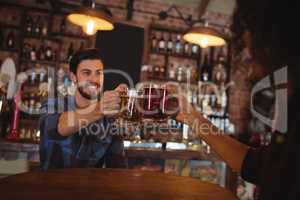 Two young men toasting their beer mugs