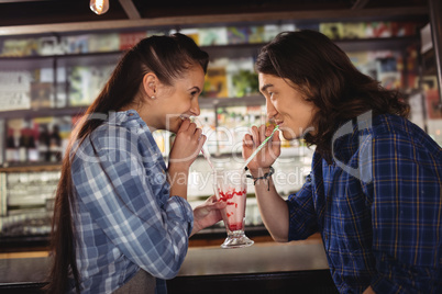 Happy couple having milkshake at counter
