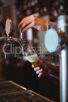 Close-up of bar tender filling beer from bar pump