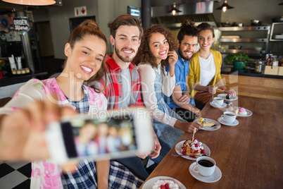 Smiling friends taking photo in pub