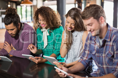 Friends using digital tablet in restaurant