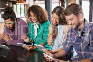 Friends using digital tablet in restaurant