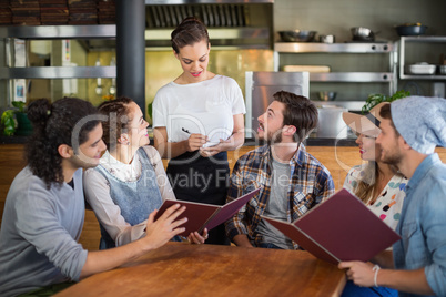 Customers looking at waitress in restaurant