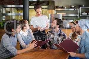 Customers looking at waitress in restaurant