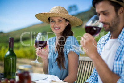 Smiling woman holding wineglass while sitting with man