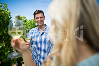 Smiling man looking at woman holding wineglasses