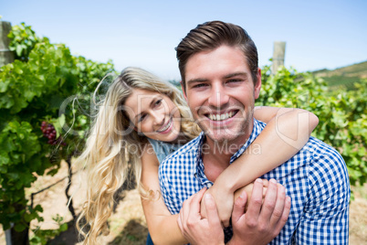 Cheerful couple embracing at vineyard