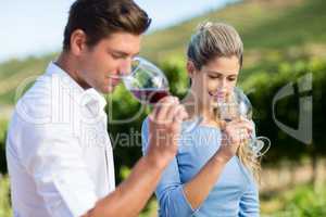 Smiling Young friends smelling wine in glasses