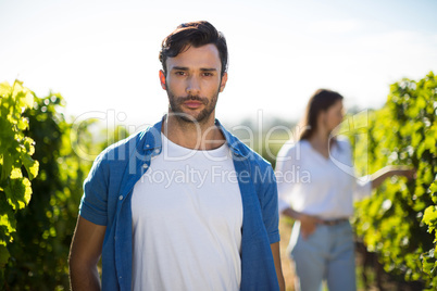 Serious young man standing at vineyard