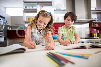 Siblings doing homework in kitchen