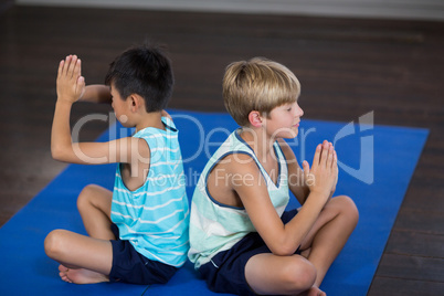 Siblings performing yoga at home