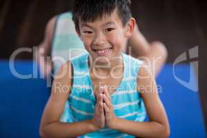 Smiling boy performing yoga at home