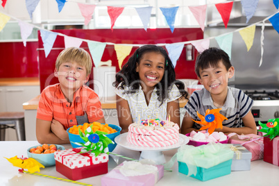 Portrait of siblings celebrating birthday in kitchen