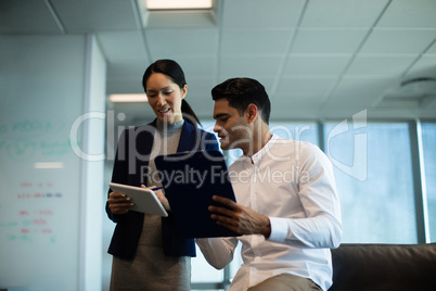 discussing while holding digital tablet and clipboard