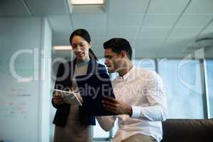 discussing while holding digital tablet and clipboard