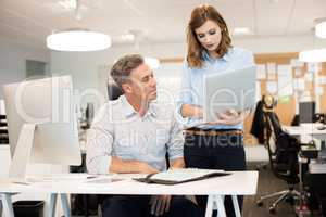 Businesswoman discussing with male colleague while working in office