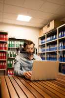 Business executive using laptop in file storage room