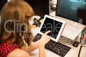Businesswoman using digital tablet at office desk