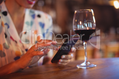 Mid-section of woman using mobile phone