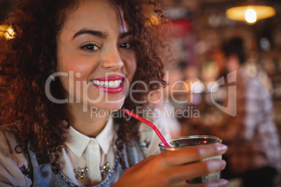 Portrait of young woman having a cocktail drink