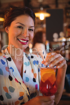 Portrait of young woman having cocktail drink