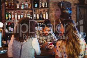 Bartender taking an order on notepad at counter