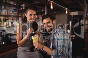 Portrait of happy couple having milkshake