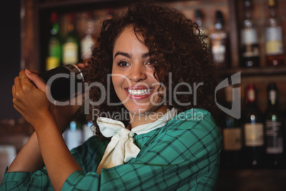 Female bartender mixing a cocktail drink in cocktail shaker
