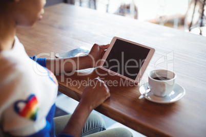 Woman using digital tablet while having coffee