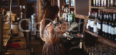 Female bar tender looking at menu