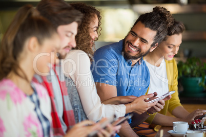Cheerful friends using mobile phone